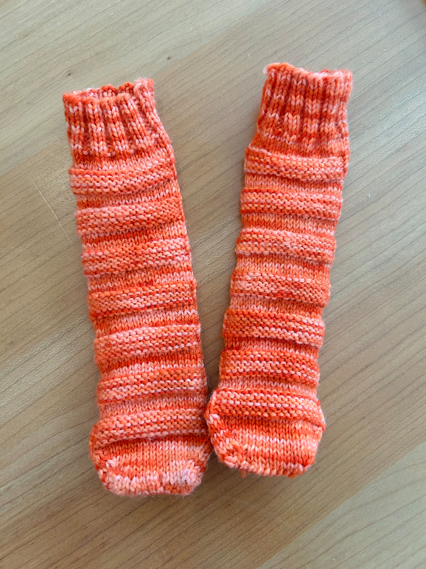 Orange baby socks, ribbed both vertically and horizontally 