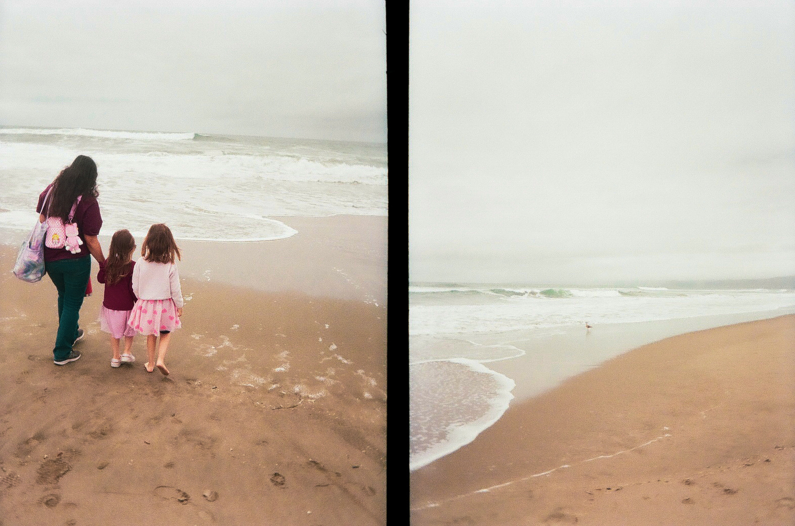 A woman and two young girls walk hand in hand along a sandy beach with waves gently approaching the shore.